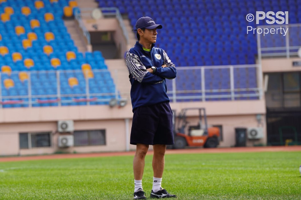 Pelatih Shin Tae Yong berdiri dan mengamati murid-muridnya berlatih.